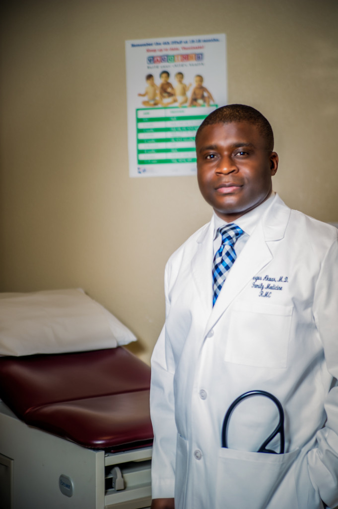 Male family medicine doctor wearing a white lab coat with a stethoscope in his pocket inside an examination room